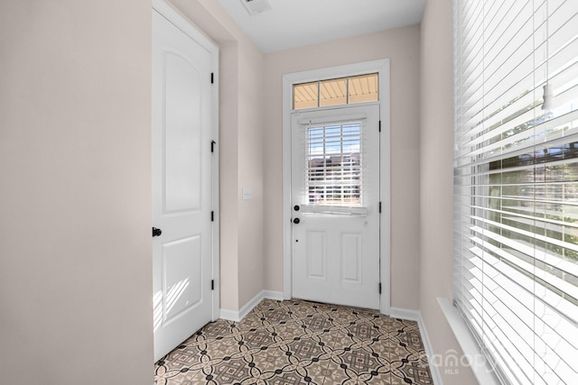 doorway featuring light tile patterned flooring, visible vents, and baseboards