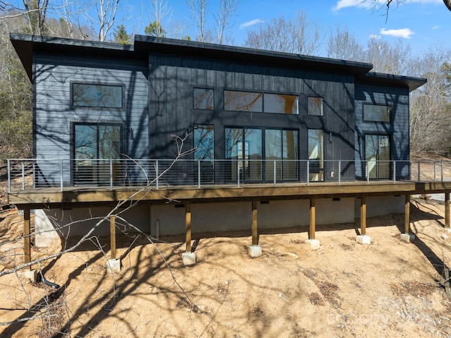 rear view of house featuring a wooden deck