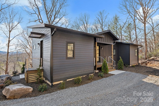 view of front facade featuring crawl space, board and batten siding, and gravel driveway