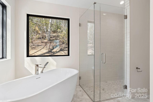 full bath featuring a stall shower and a freestanding tub