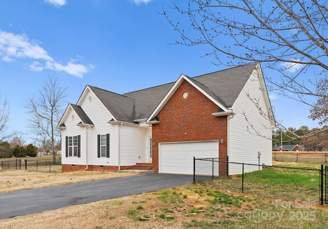 exterior space featuring fence, roof with shingles, driveway, a garage, and crawl space