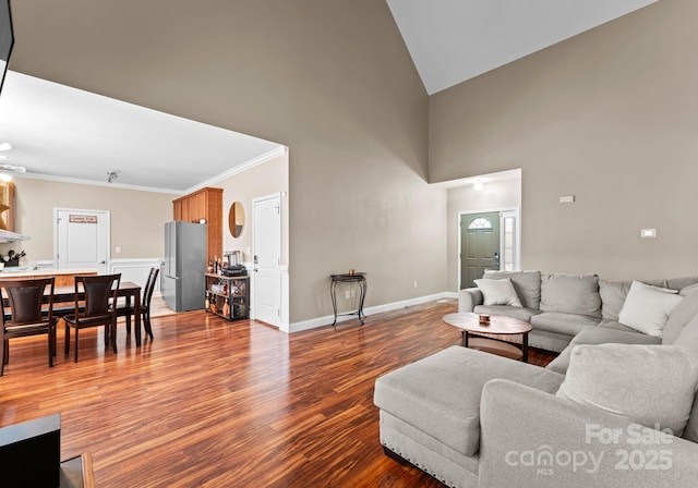 living area featuring high vaulted ceiling, crown molding, baseboards, and wood finished floors