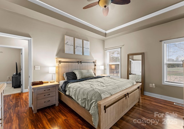 bedroom featuring visible vents, baseboards, a tray ceiling, ornamental molding, and dark wood-style floors