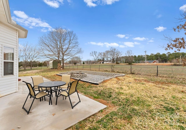 view of yard with outdoor dining space, an outdoor structure, a patio area, and a shed