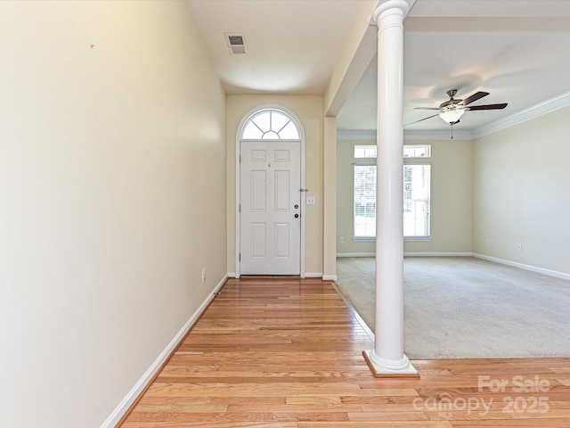 entrance foyer featuring decorative columns, baseboards, visible vents, and ceiling fan