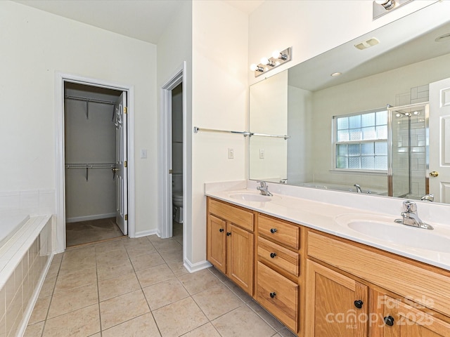 full bathroom with tile patterned floors, double vanity, a stall shower, and a sink