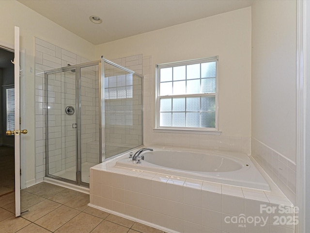 bathroom featuring tile patterned flooring, a garden tub, and a stall shower