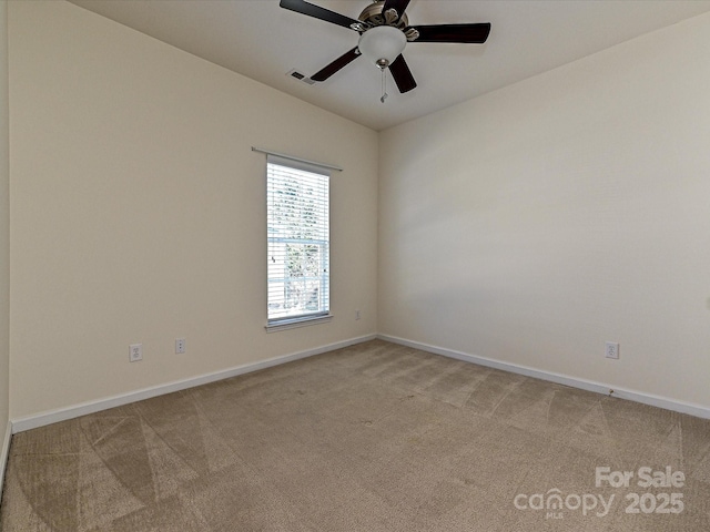 unfurnished room with visible vents, light colored carpet, a ceiling fan, and baseboards