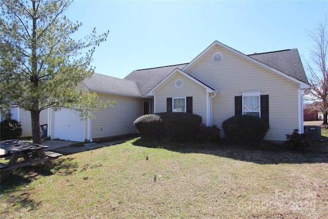 single story home featuring a shingled roof, an attached garage, and a front yard