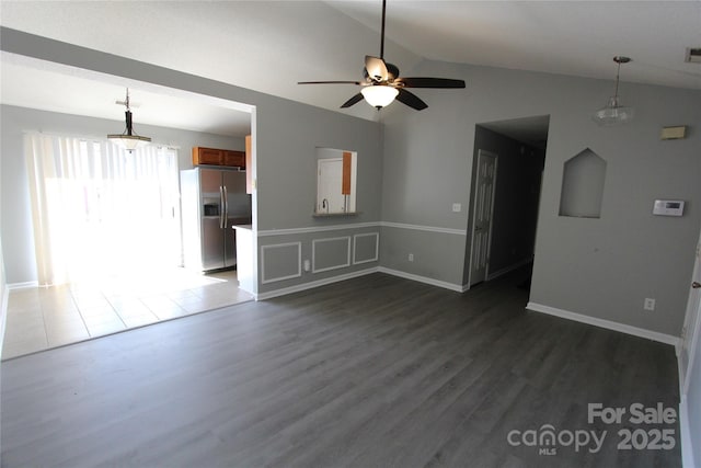 unfurnished living room featuring dark wood-style flooring, lofted ceiling, visible vents, a ceiling fan, and baseboards