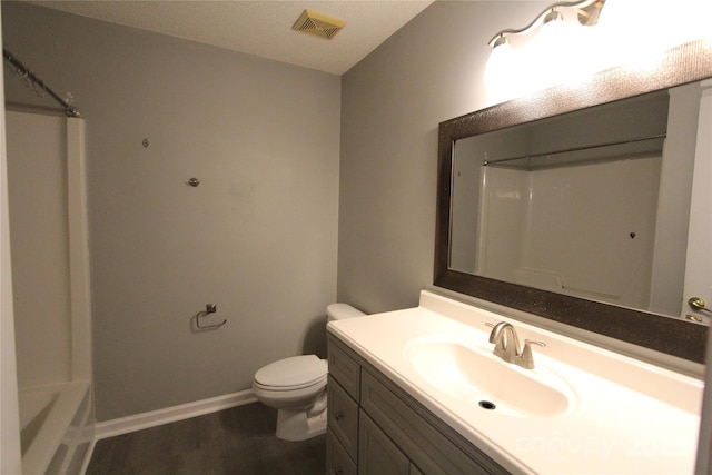 bathroom with baseboards, visible vents, toilet, wood finished floors, and vanity