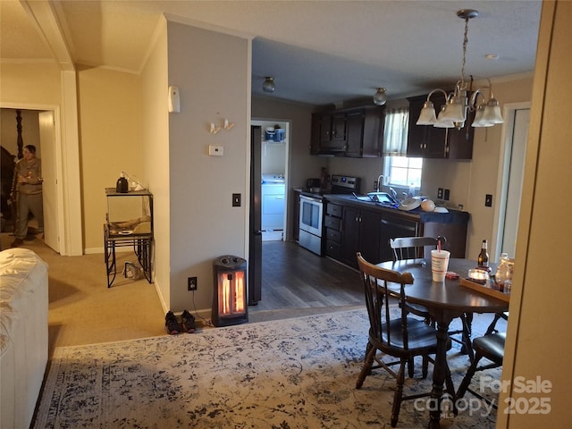 kitchen featuring arched walkways, crown molding, washer / clothes dryer, electric range, and baseboards