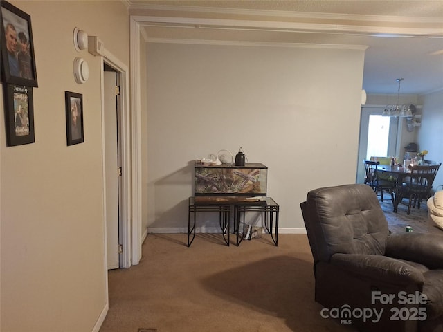 interior space with ornamental molding, carpet, a notable chandelier, and baseboards