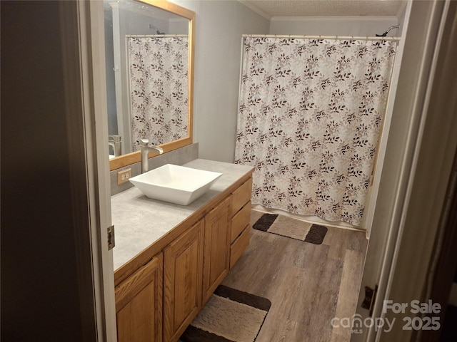 full bathroom featuring curtained shower, vanity, crown molding, and wood finished floors