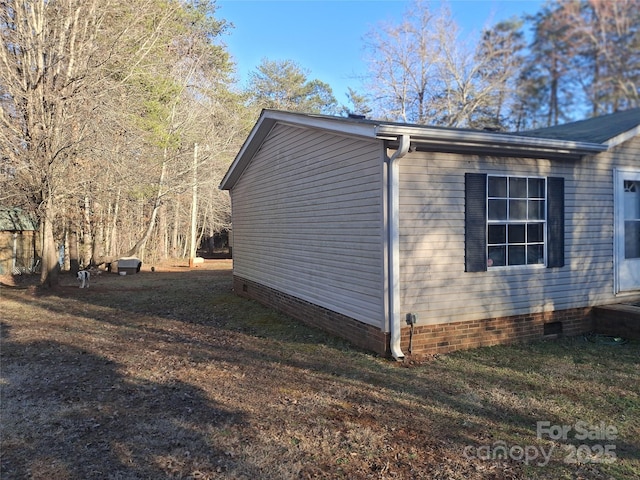 view of side of home featuring crawl space and a yard