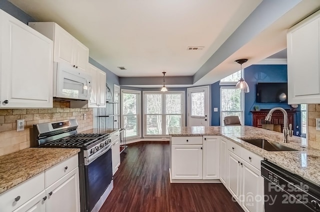 kitchen with white microwave, visible vents, stainless steel range with gas stovetop, a sink, and black dishwasher