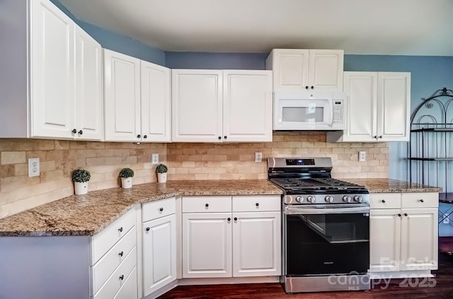 kitchen with backsplash, gas range, white microwave, and white cabinets