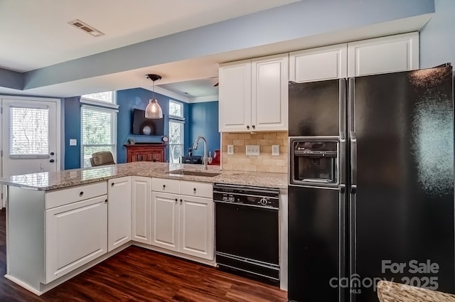 kitchen with visible vents, a peninsula, a sink, black appliances, and white cabinets