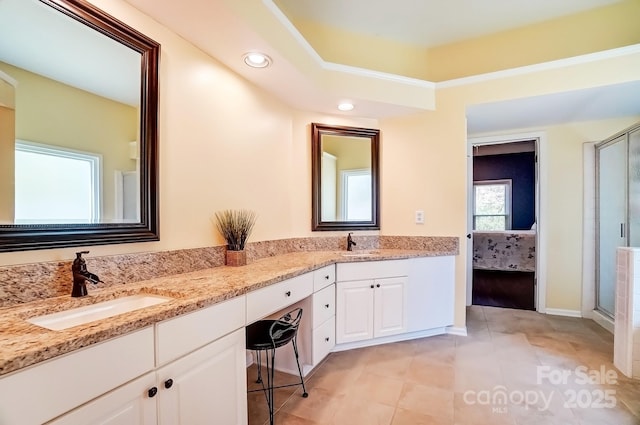 ensuite bathroom featuring double vanity, connected bathroom, a shower stall, and a sink