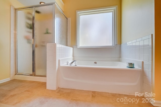 full bathroom featuring tile patterned flooring, a shower stall, and a garden tub