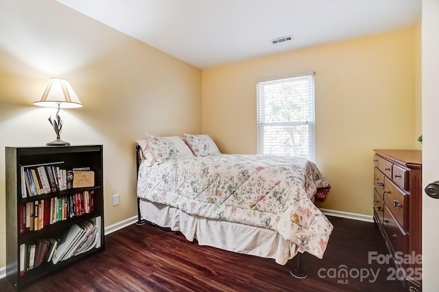 bedroom with visible vents, baseboards, and wood finished floors