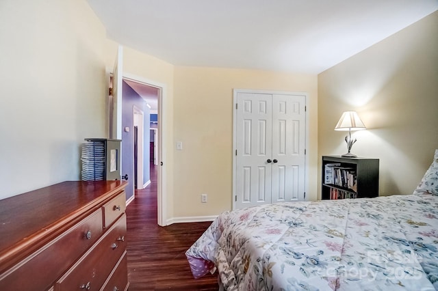 bedroom featuring baseboards, dark wood-style flooring, and a closet