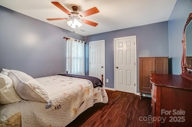 bedroom with visible vents, baseboards, dark wood-style floors, and a ceiling fan