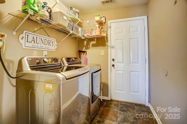 clothes washing area with visible vents, baseboards, independent washer and dryer, and laundry area