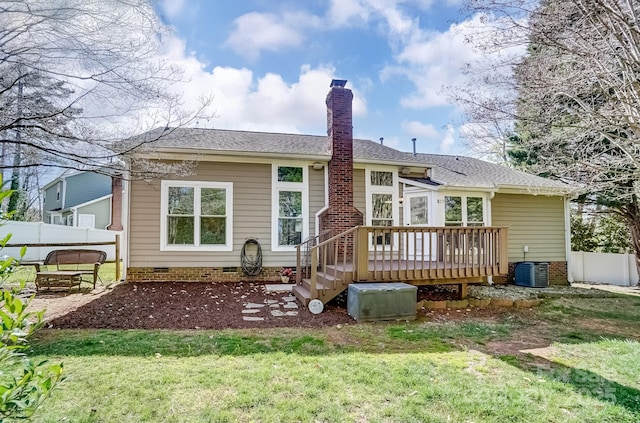 rear view of house with fence, a wooden deck, a chimney, a yard, and crawl space