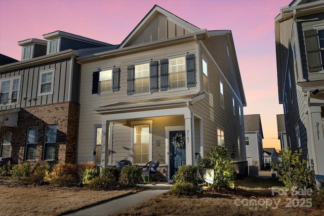 townhome / multi-family property with board and batten siding and a porch