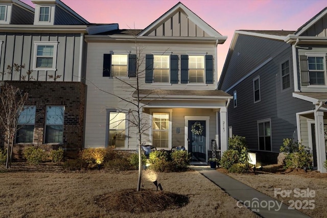 view of front of property featuring board and batten siding and brick siding