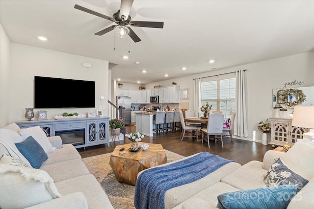 living room with dark wood-type flooring, stairway, a ceiling fan, and recessed lighting