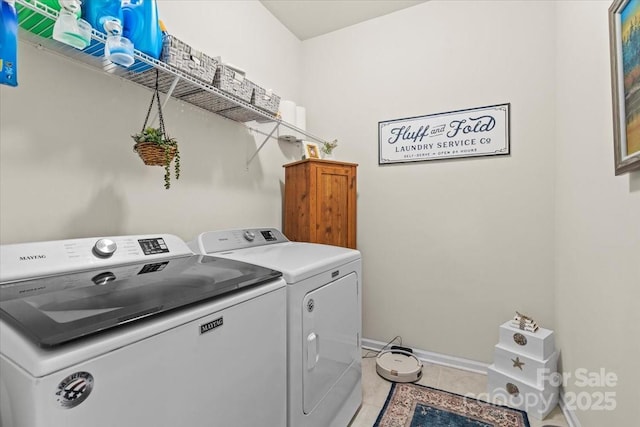 clothes washing area featuring laundry area, independent washer and dryer, light tile patterned flooring, and baseboards