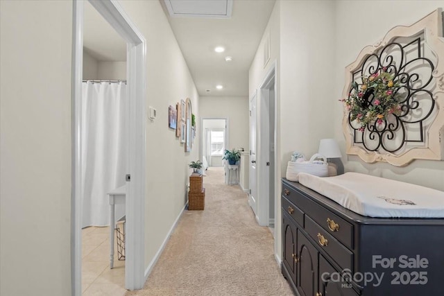 hallway with baseboards, light tile patterned floors, recessed lighting, and light colored carpet