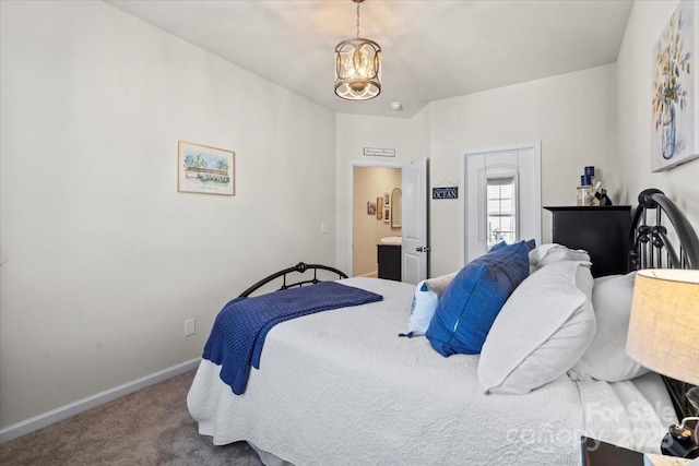 carpeted bedroom featuring a chandelier and baseboards