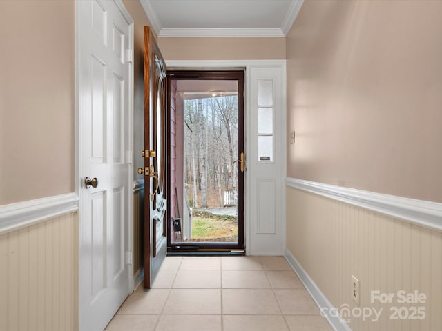 entryway featuring light tile patterned flooring, wainscoting, and ornamental molding