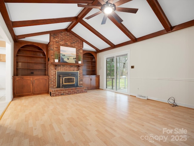 unfurnished living room featuring visible vents, built in shelves, and wood finished floors