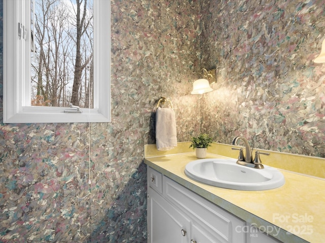 bathroom featuring wallpapered walls and vanity