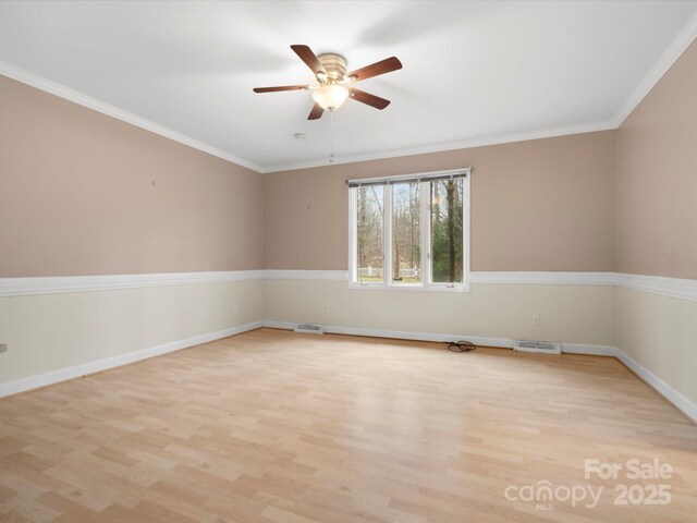 unfurnished room with crown molding, light wood-style floors, and visible vents