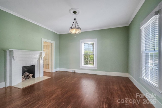 unfurnished living room with crown molding, a fireplace, baseboards, and wood finished floors