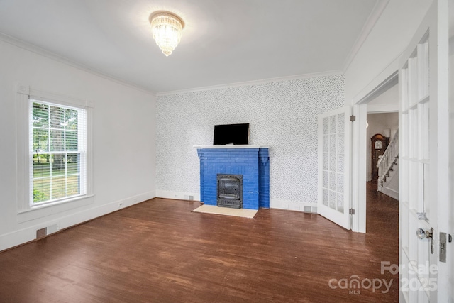 unfurnished living room with wood finished floors, crown molding, baseboards, and wallpapered walls