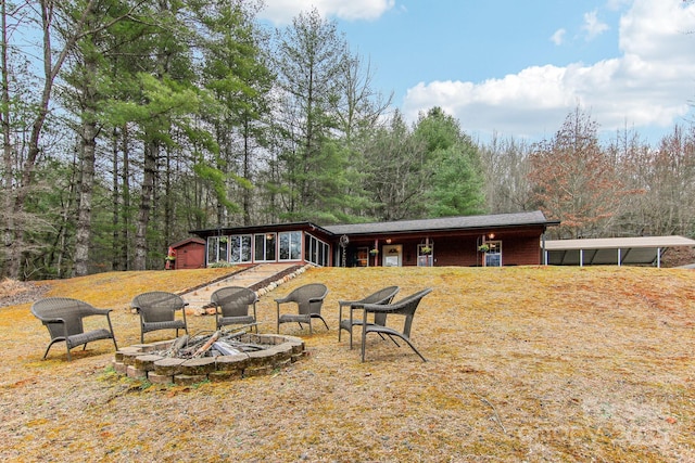 rear view of property featuring an outdoor fire pit