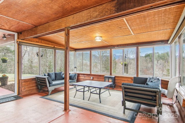 sunroom / solarium featuring ceiling fan, wood ceiling, and a healthy amount of sunlight