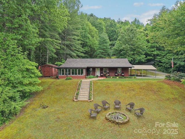 211 Heartland Rdg, Sylva, NC 28779 - view of front facade with a detached carport, a front lawn, a forest view, a storage unit, and covered porch