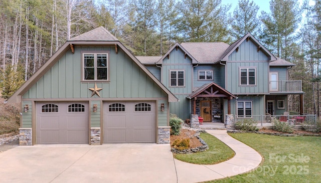 craftsman-style home with a garage, a porch, board and batten siding, and roof with shingles