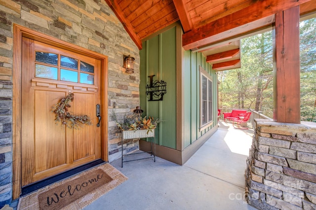 property entrance featuring stone siding and a porch