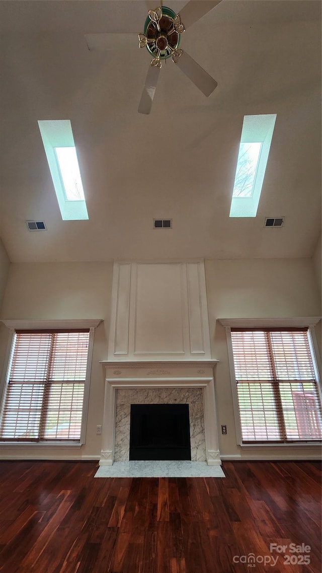 unfurnished living room featuring plenty of natural light, a fireplace, and visible vents