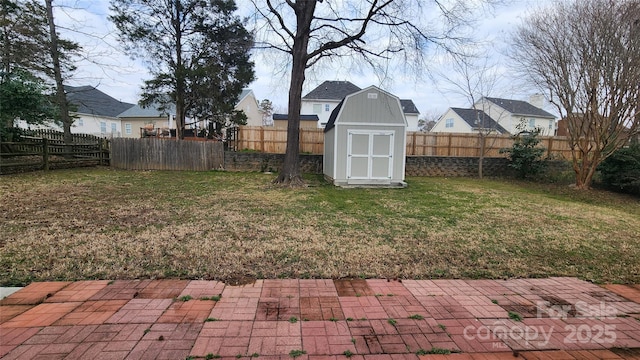 view of yard with a patio area, a fenced backyard, a storage unit, and an outbuilding
