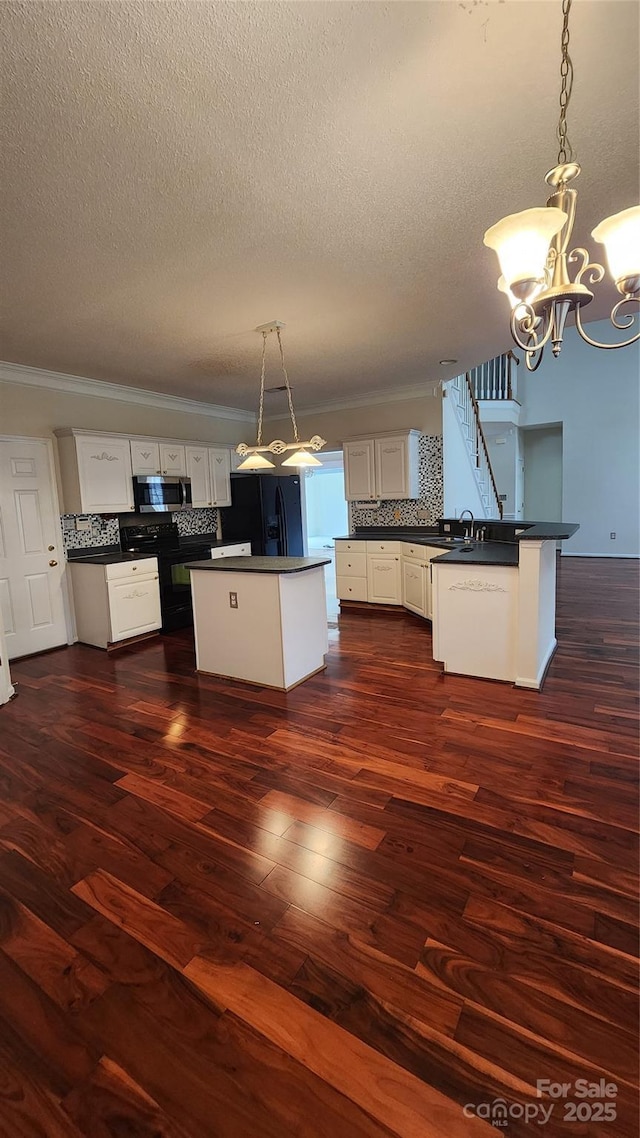 kitchen with dark wood-style flooring, backsplash, black appliances, dark countertops, and crown molding