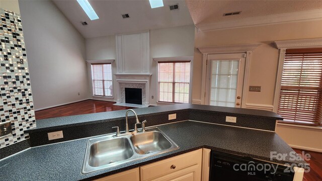 kitchen featuring dark countertops, visible vents, open floor plan, and a sink